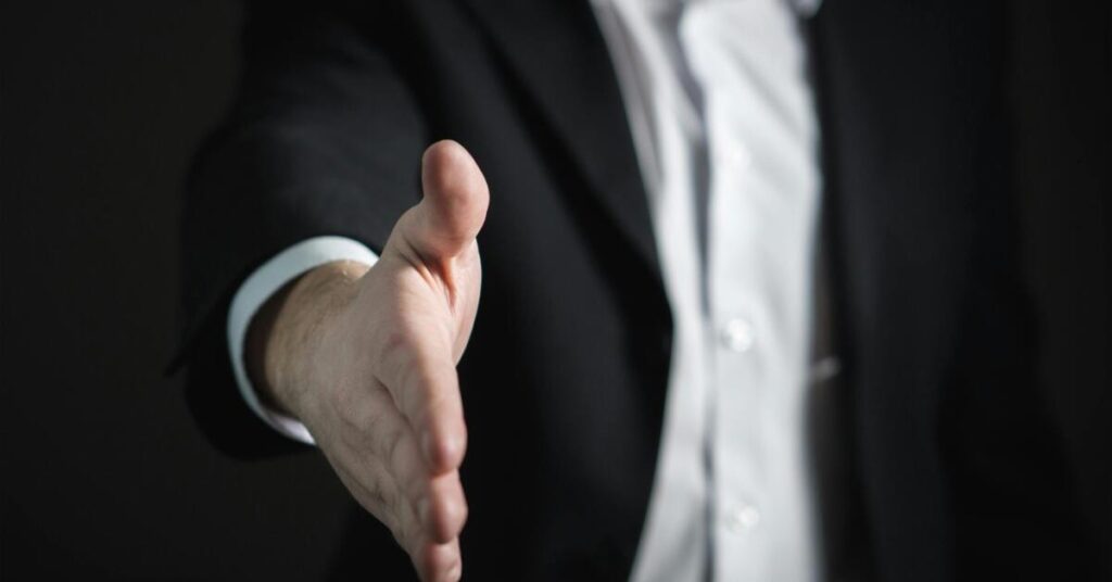 An insurance adjuster offering a settlement check as part of the car accident insurance claim process.